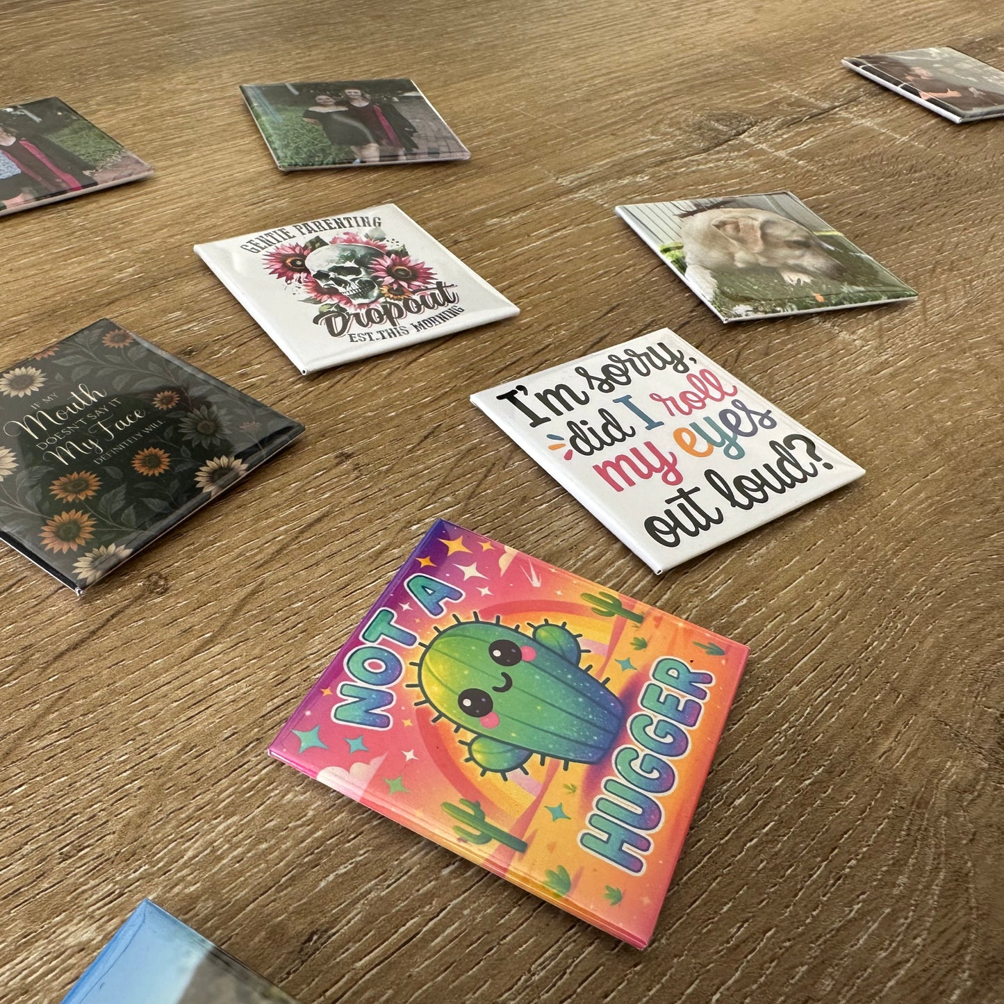 Set of colorful magnets with various designs on a wooden surface